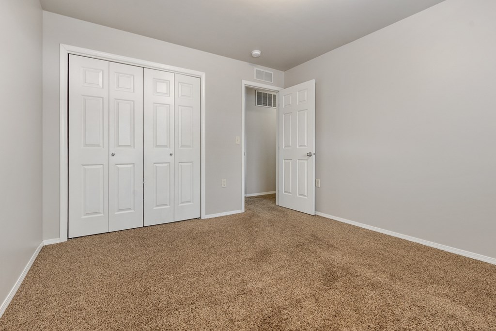 A room with white doors and a brown carpet.