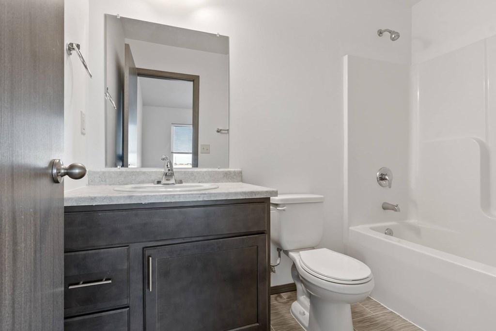 A bathroom with a toilet, sink, and bathtub.