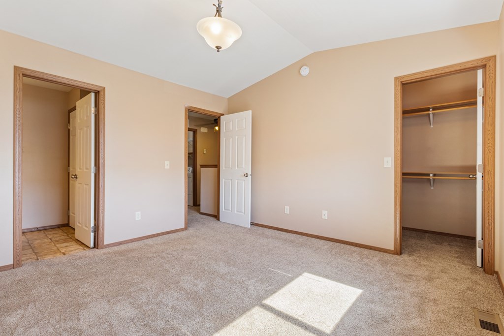A spacious room with a carpeted floor and a ceiling light.