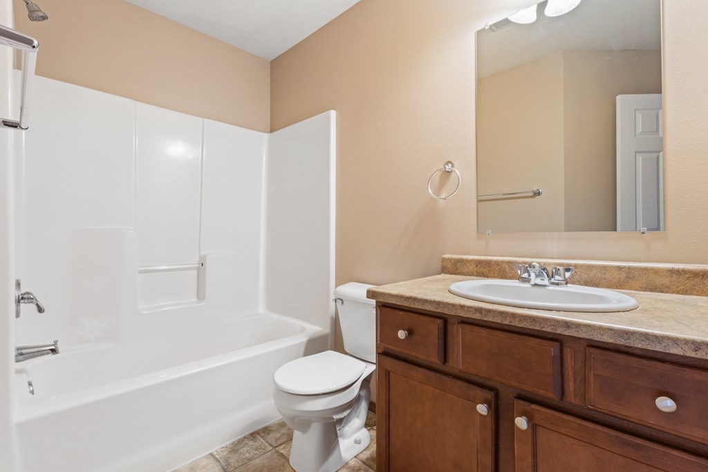 A bathroom with a white toilet, sink, and bathtub.