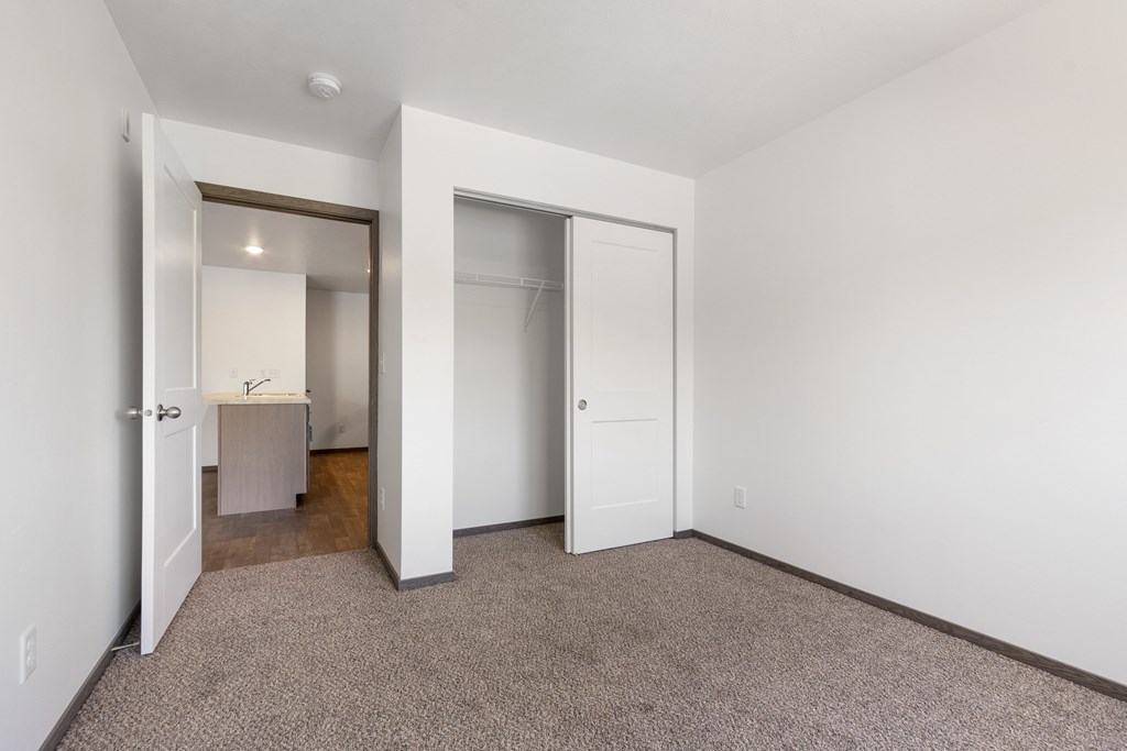 A room with a carpeted floor and a white door.