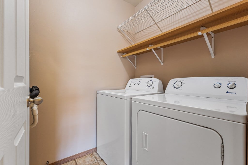 A white washing machine and dryer in a laundry room.