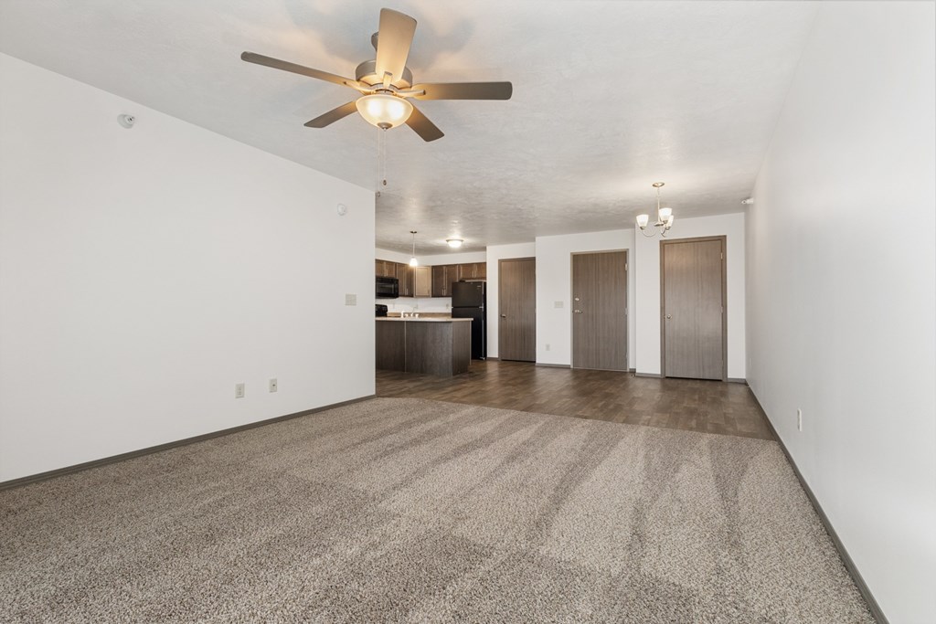 A room with a ceiling fan and carpeted floor.