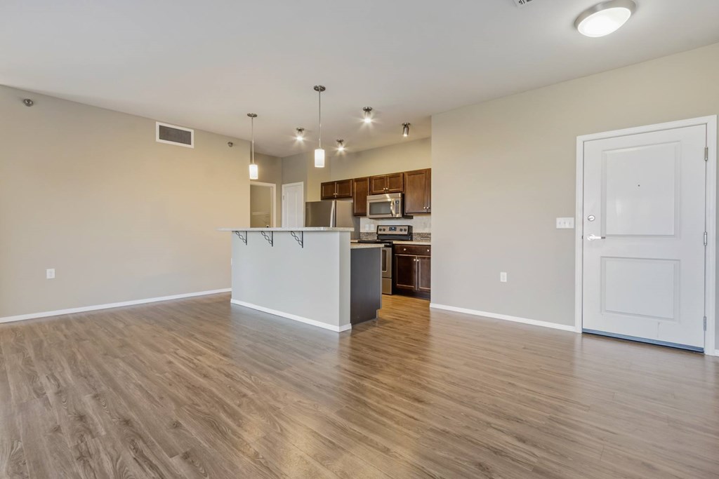 A kitchen area with a white countertop and wooden flooring.