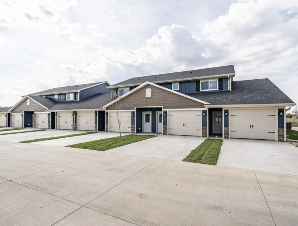 the front of a house with white garage doors