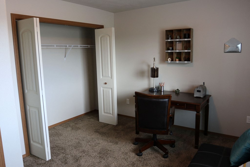 a room with a desk and a closet and a chair