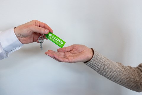 a man holding a condom in his hand and another person holding a key