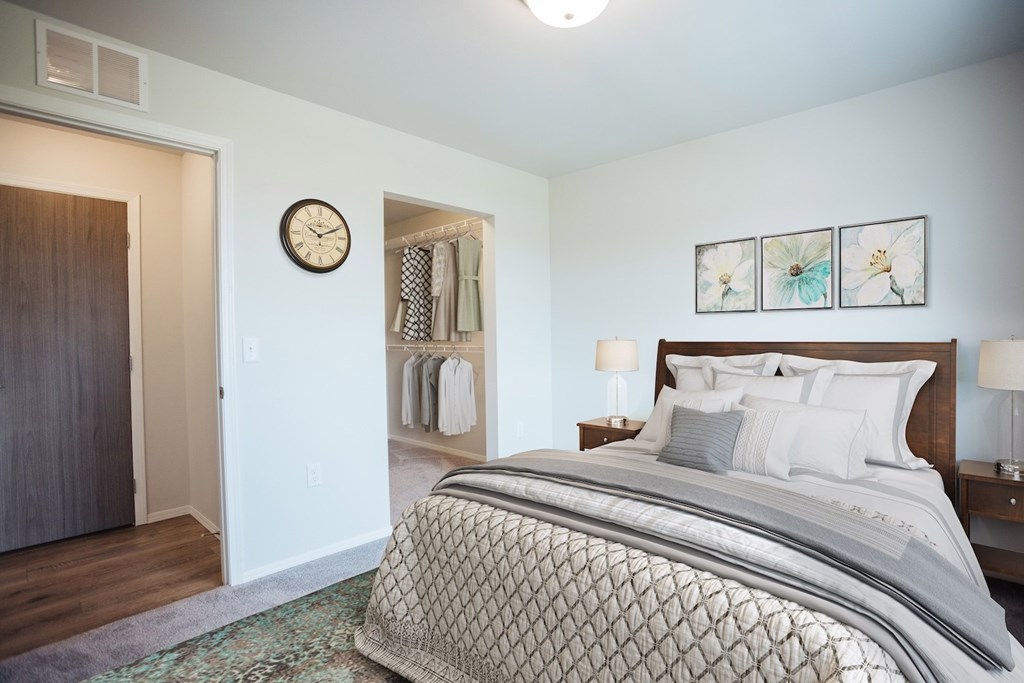 A bedroom with a large bed and a clock on the wall.