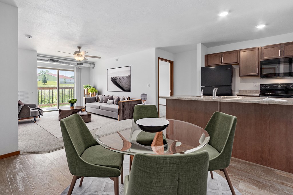A modern dining room with a glass table and green chairs.