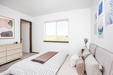 A bedroom with a large bed and a window.
