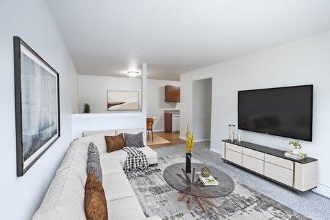 A living room with a white couch, a coffee table, and a large painting on the wall.