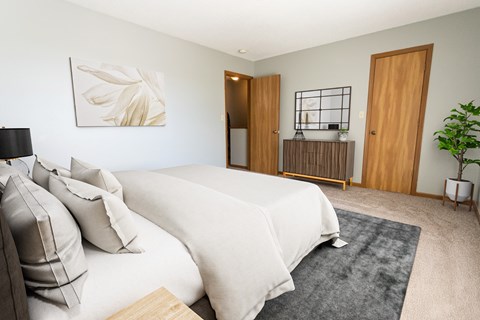 A bedroom with a large bed and a painting on the wall.