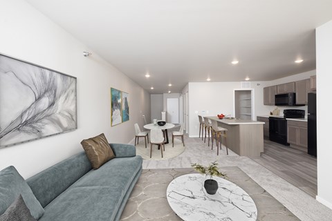 A living room with a grey couch and a white coffee table.