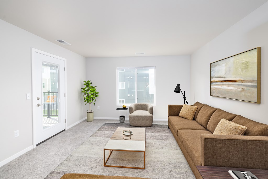 A living room with a brown couch, a coffee table, and a painting on the wall.