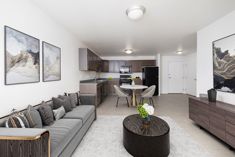 A living room with a grey couch and a coffee table in the middle.