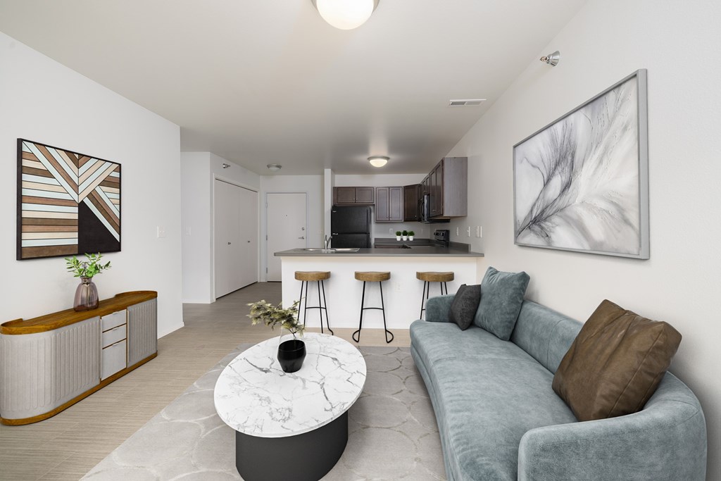 A modern living room with a grey couch and a marble coffee table.