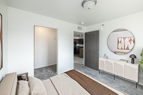 A living room with a couch and a mirror on the wall.