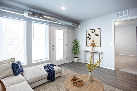 A living room with a white couch and a wooden coffee table.