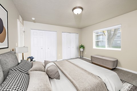 A bedroom with a large bed and a window.