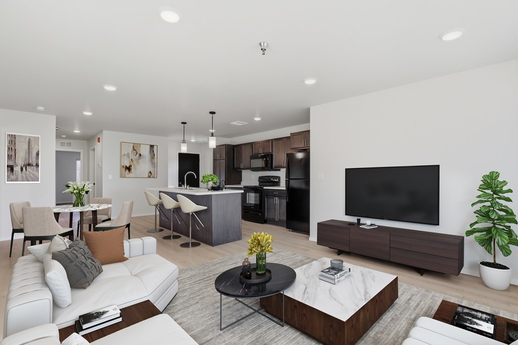 A modern living room with a white sofa, a black coffee table, and a flat-screen TV.