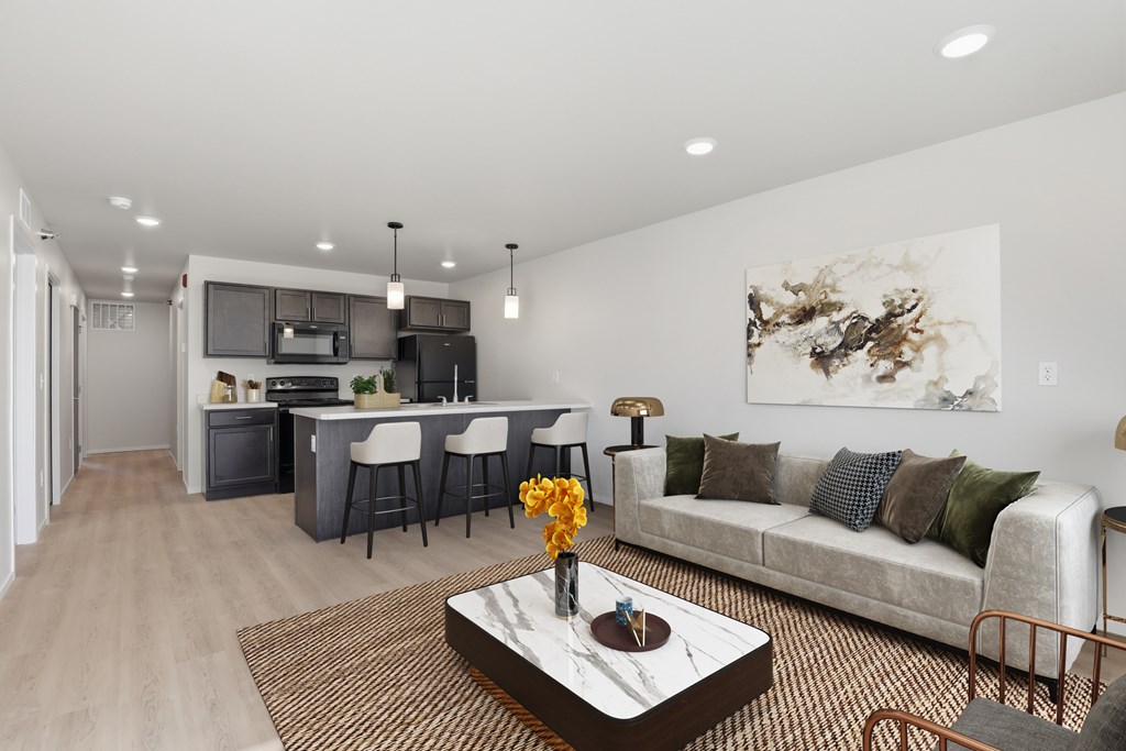 A modern living room with a kitchen in the background.