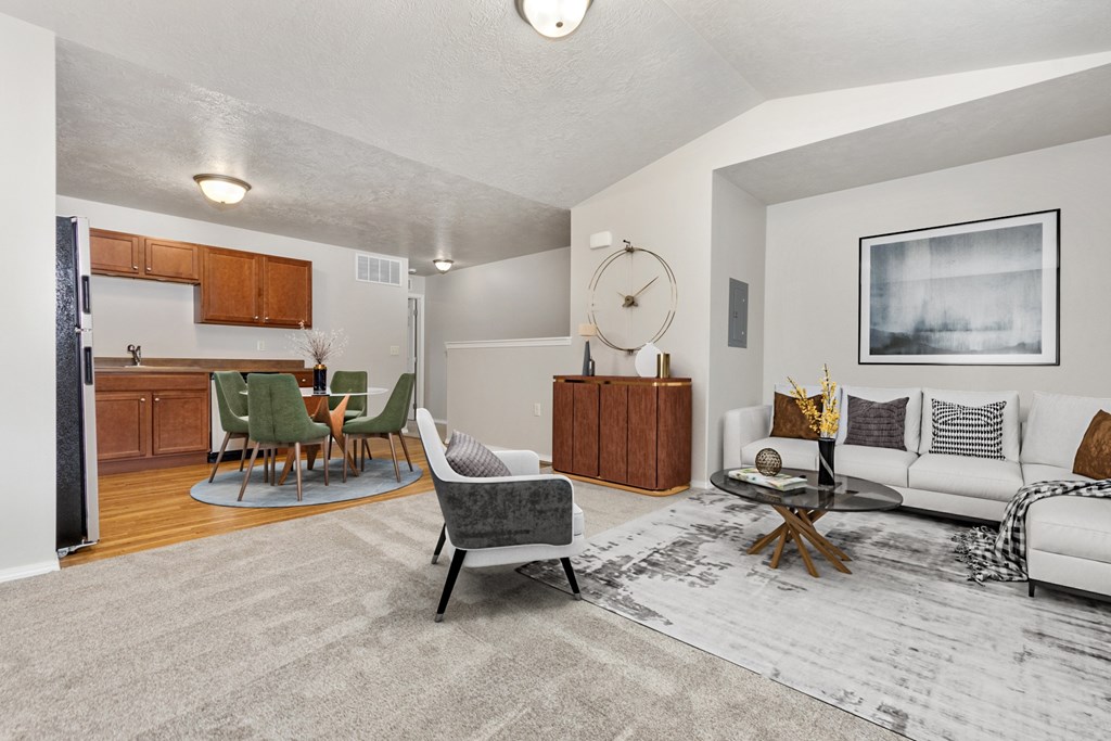 A living room with a grey rug and a white couch.