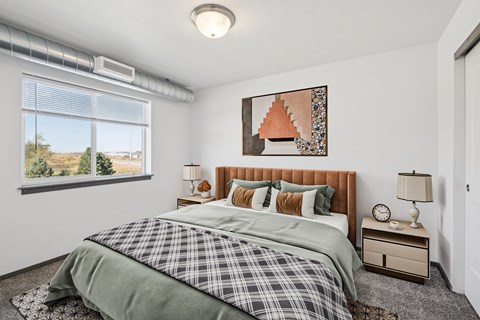 A bedroom with a large bed and a window overlooking a landscape.