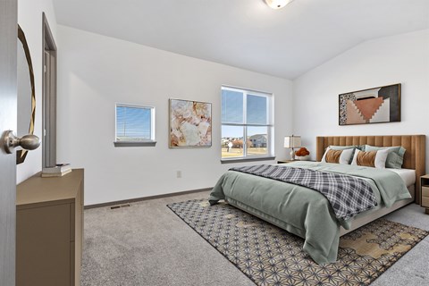 A bedroom with a bed, a dresser, and a window.