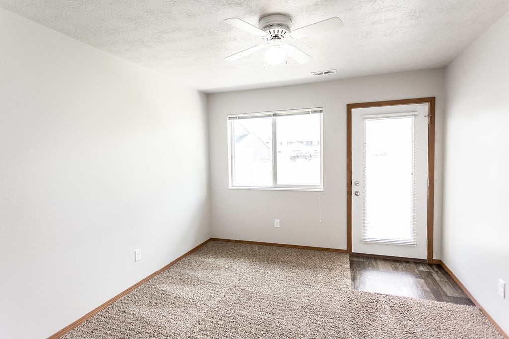an empty room with a ceiling fan and a window