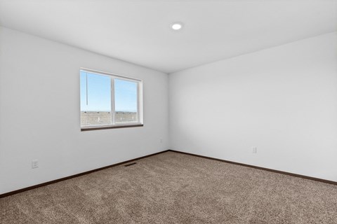 an empty room with carpet and a window