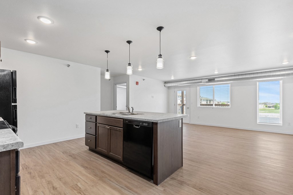 the living room and kitchen in a new home with white walls and wood floors