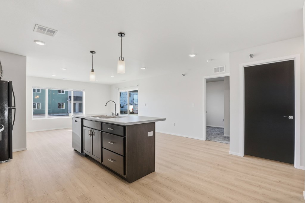 A kitchen with a black door and a black fridge.