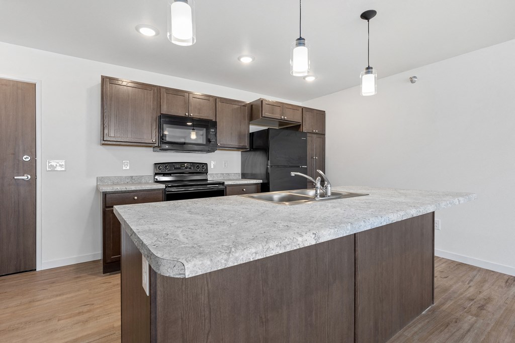 a kitchen with a marble counter top and wooden cabinets
