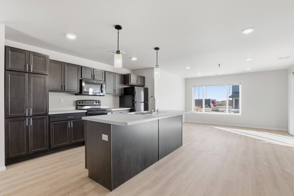 A modern kitchen with dark wood cabinets and a large island.
