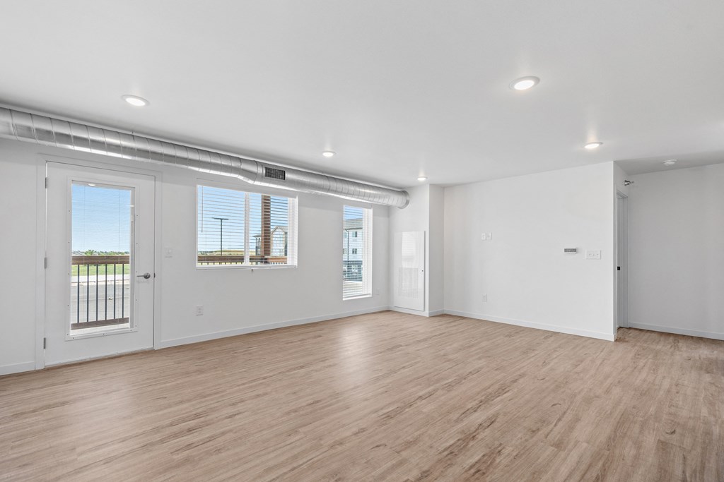 an empty living room with white walls and wood floors