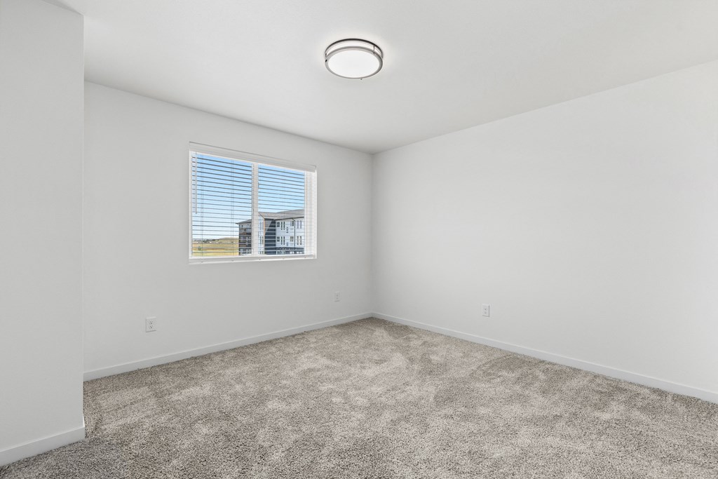 an empty room with carpet and a window