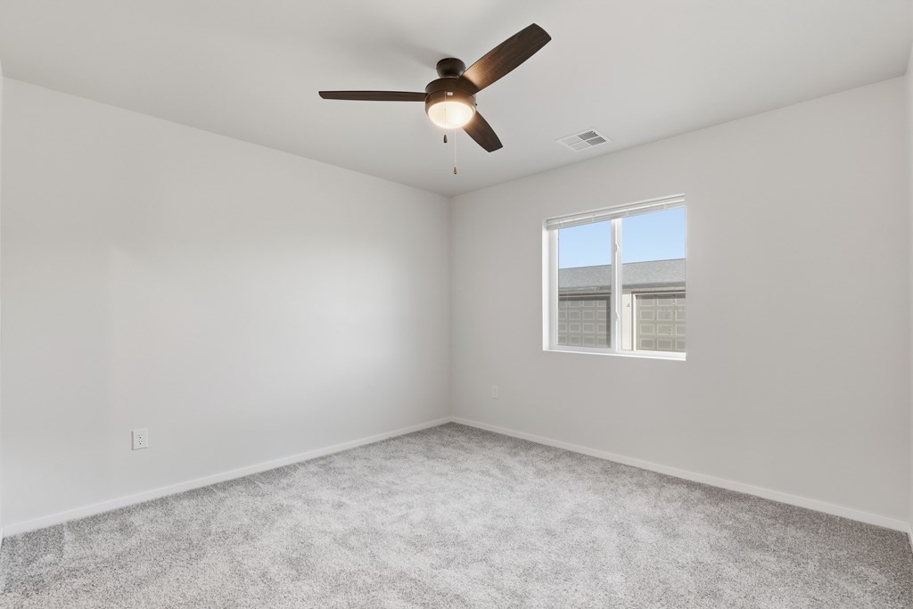 A room with a ceiling fan and a window.