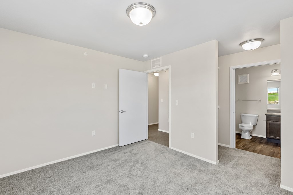 an empty room with a bathroom and a toilet and a closet