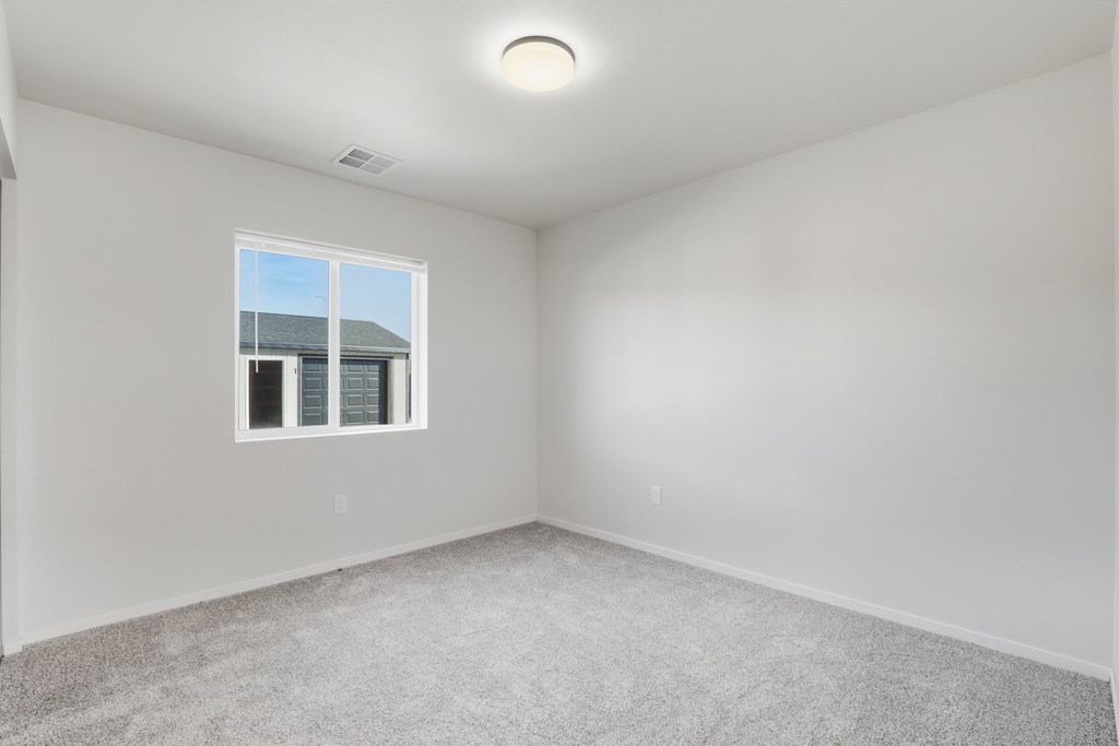 A room with a window and carpeted floor.