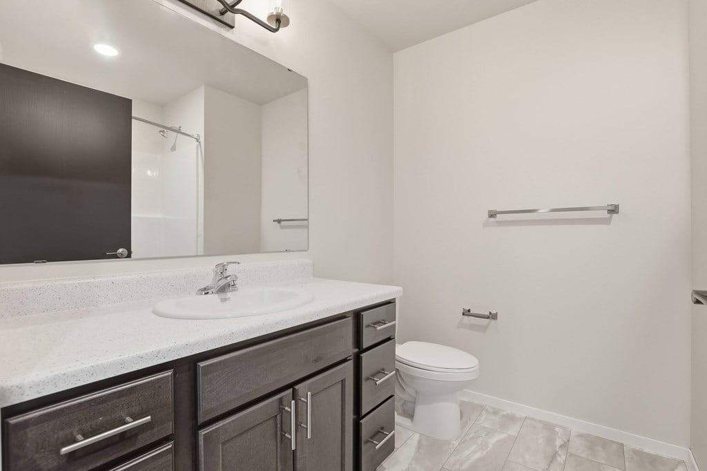 A bathroom with a white sink and a toilet.