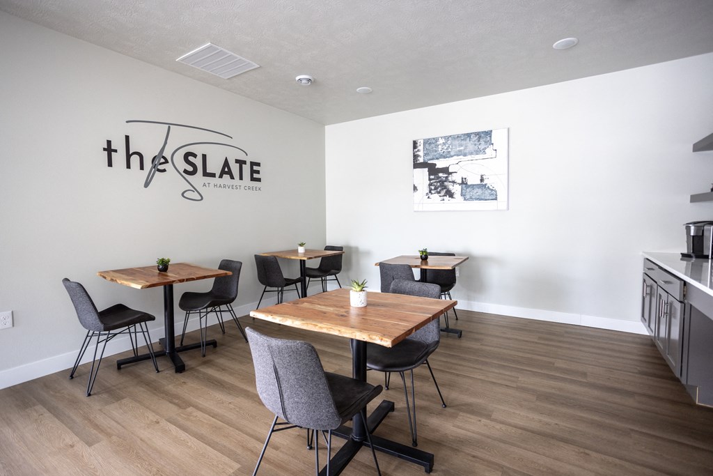 the slate common room with tables and chairs and the slate logo on the wall