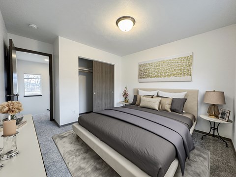 A bedroom with a large bed and a painting on the wall.