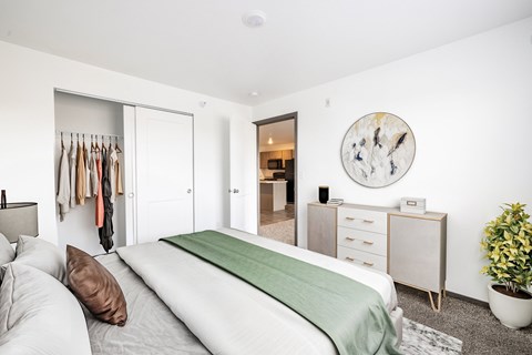 A bedroom with a bed, dresser, and mirror.