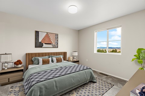 A bedroom with a bed, nightstand, and window.