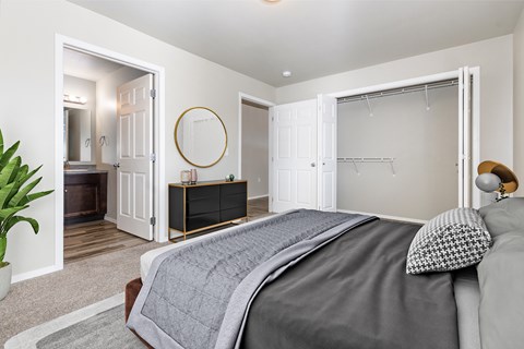 A bedroom with a large bed and a dresser with a mirror.