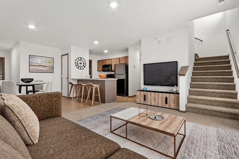 A living room with a brown couch and a wooden coffee table.