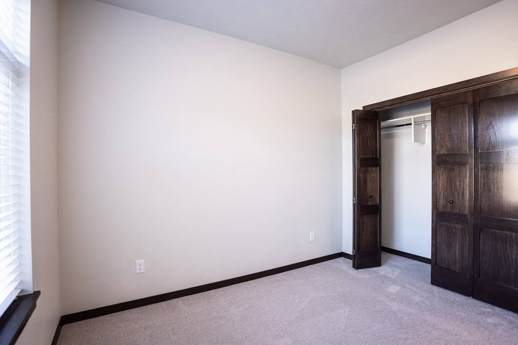 an empty room with a door to a closet