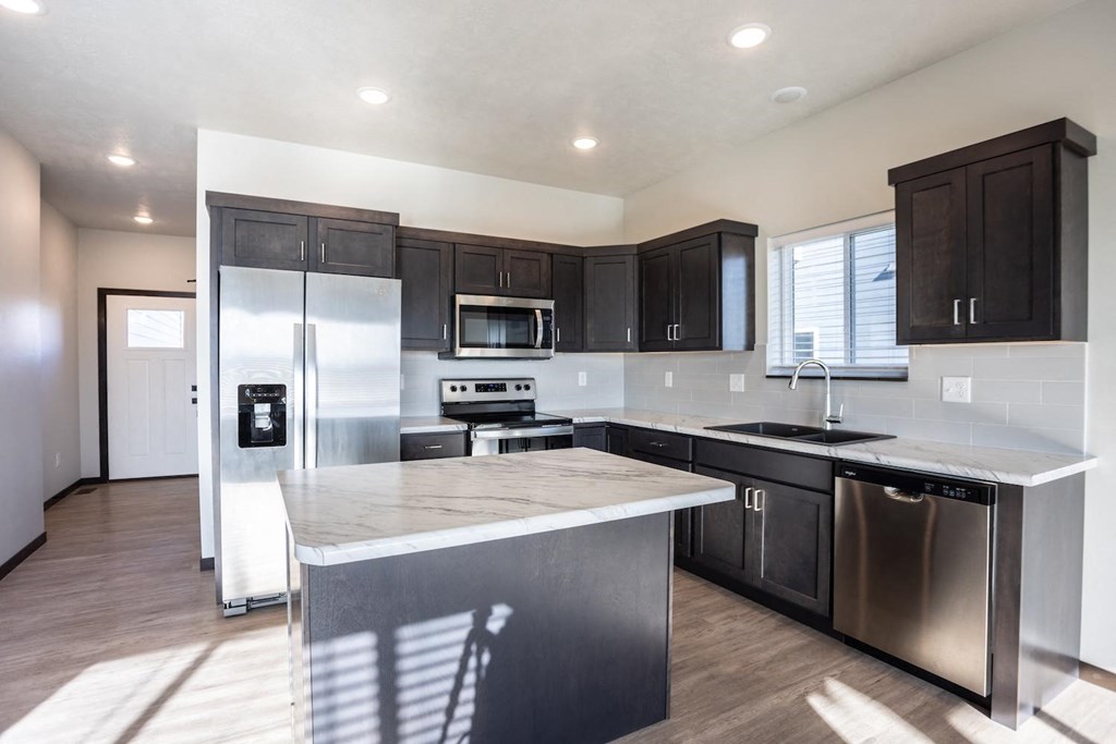 a kitchen with stainless steel appliances and a marble counter top