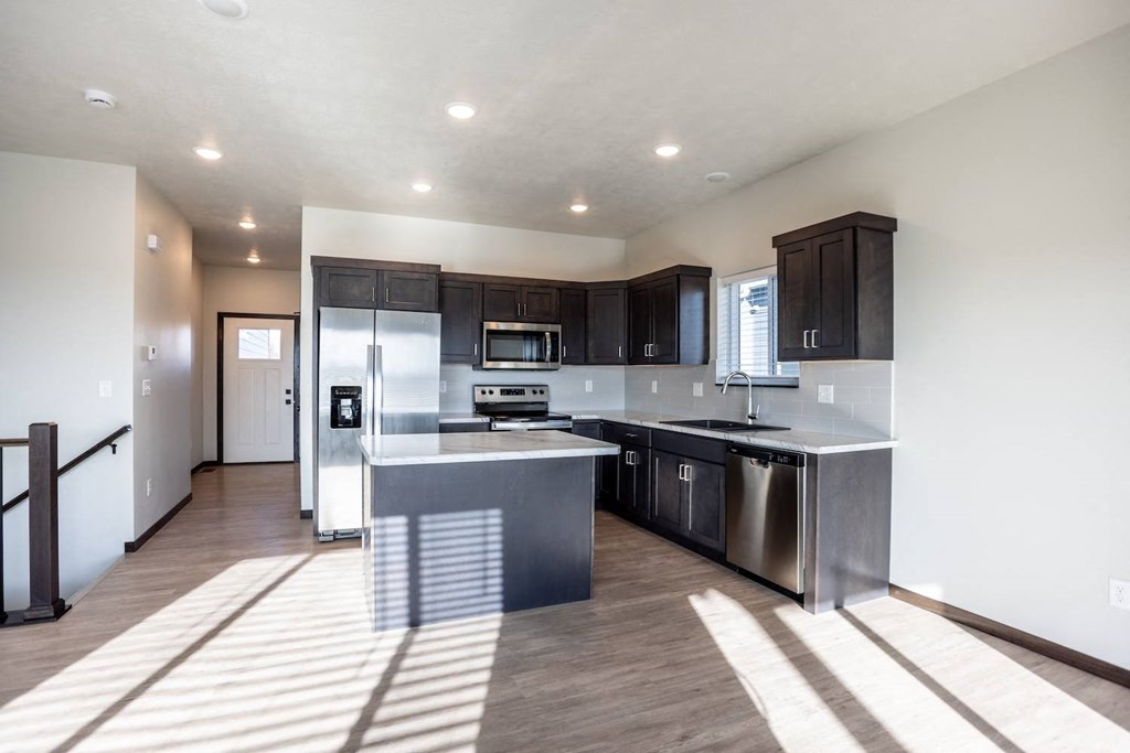 a modern kitchen with stainless steel appliances and a large island