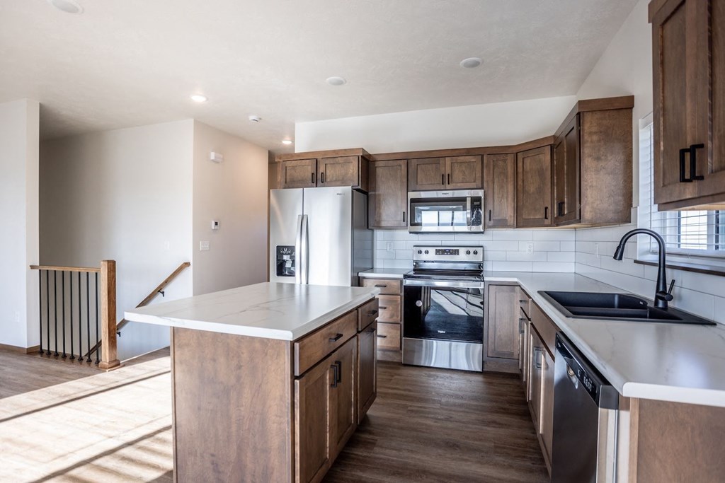 a kitchen with wooden cabinets and stainless steel appliances